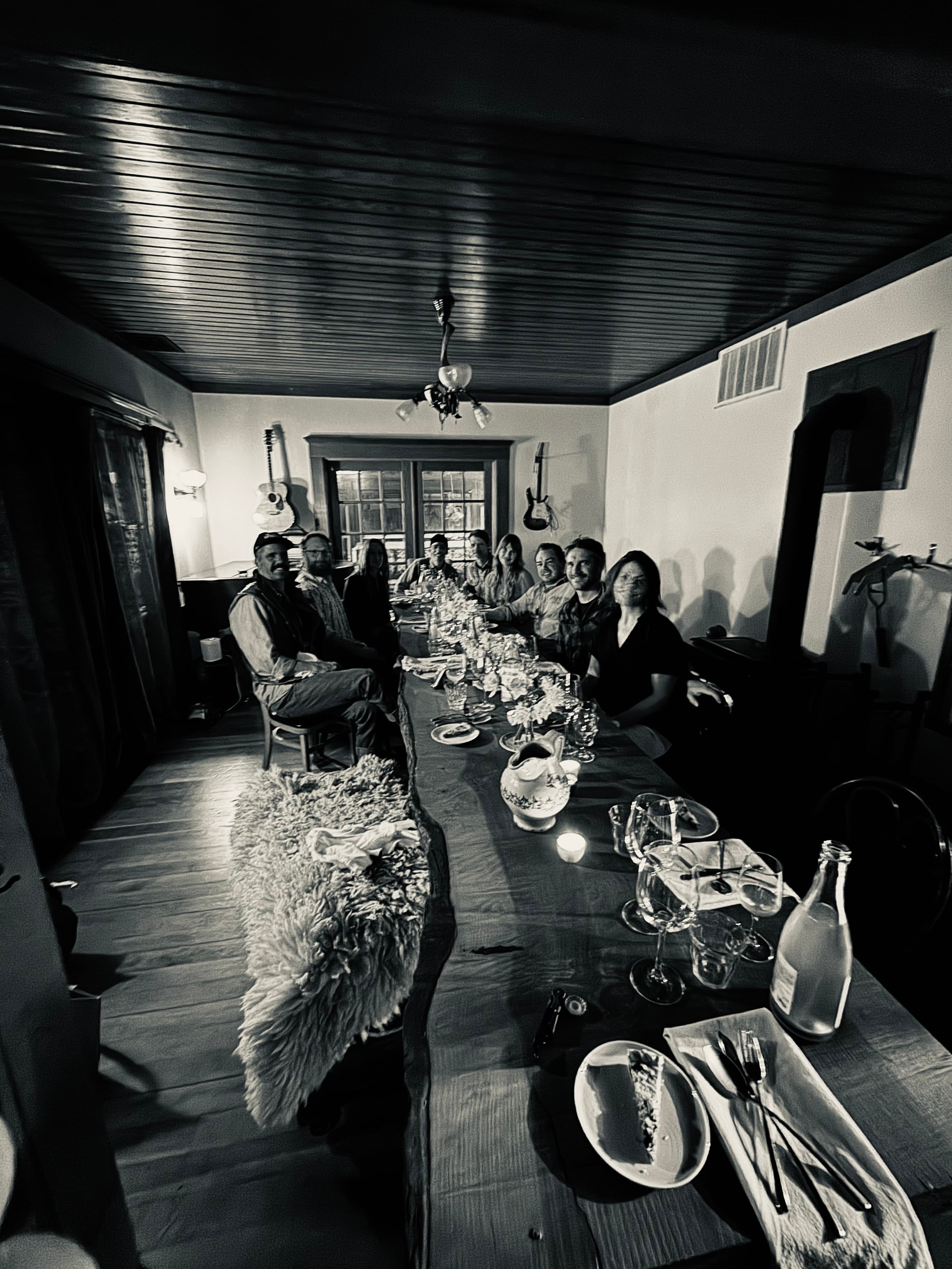 Guests gathered for dinner at the long farmhouse table